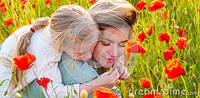 Mother and daughter on the poppies field background. Spring family banner. Portrait of mother and daughter walking Stock Photo