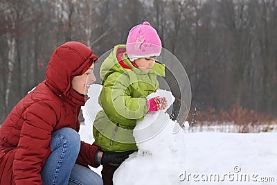 Mother with daughter sculpt snowman Stock Photo