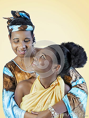 Mother and daughter smiling and hugging each other, family love, isolated, light orange background Stock Photo