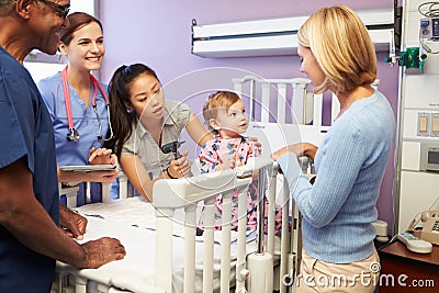 Mother And Daughter With Staff In Pediatric Ward Of Hospital Stock Photo