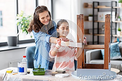 mother and daughter sticking masking tape to table Stock Photo