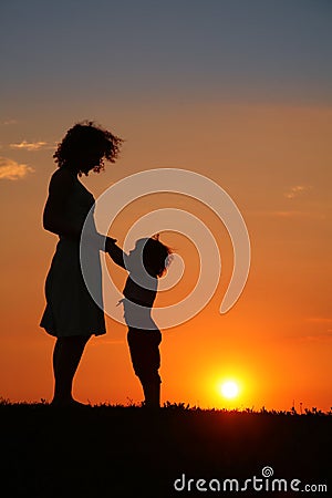 Mother and daughter on sunset silhouette Stock Photo