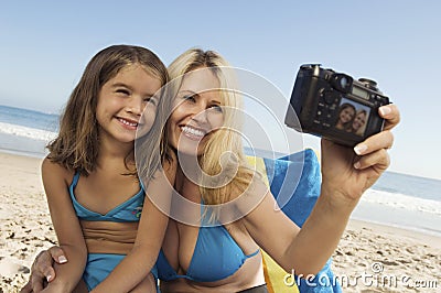 Mother And Daughter Taking Self Portrait On Beach Stock Photo