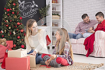 Mother and daughter unwrapping gifts Stock Photo