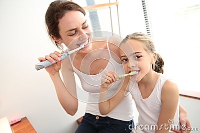 Mother and daughter using tooth brushes Stock Photo