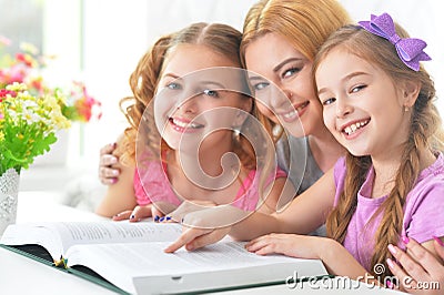 Mother with daughters reading Stock Photo