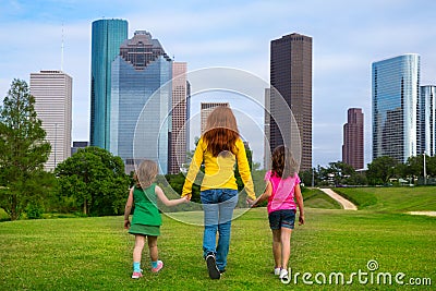 Mother and daughters walking holding hands on city skyline Stock Photo