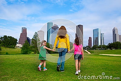 Mother and daughters walking holding hands on city skyline Stock Photo