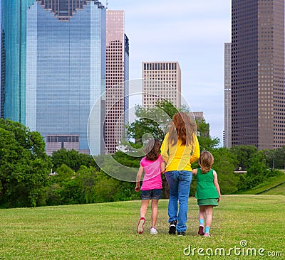 Mother and daughters walking holding hands on city skyline Stock Photo