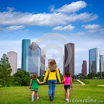 Mother and daughters walking holding hands on city skyline Stock Photo