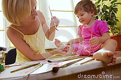 Mother drawing on her daughter Stock Photo