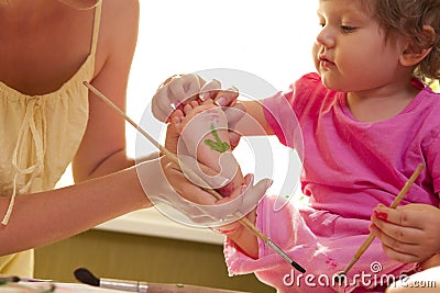 Mother drawing on her daughter Stock Photo
