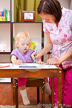 Mother drawing with her daughter Stock Photo