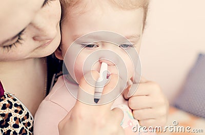 Mother drips drops in the nose of a small child Stock Photo