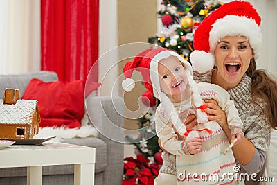 Mother and eat smeared baby in Christmas hats Stock Photo