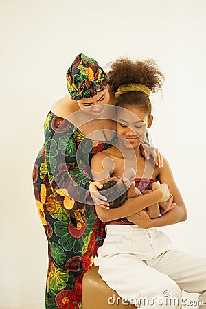 Mother and eldest daughter together carry embrace newborn baby Stock Photo