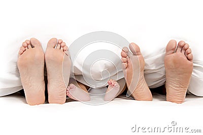 Mother Father and Baby Feet under Blanket Stock Photo