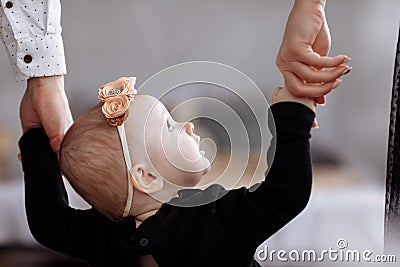 Mother, father hold hands daughter enjoy time together at home. View down the legs. Mother`s, father`s, baby`s day. concept of Stock Photo