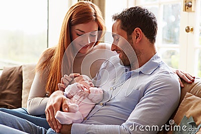 Mother And Father At Home With Newborn Baby Stock Photo