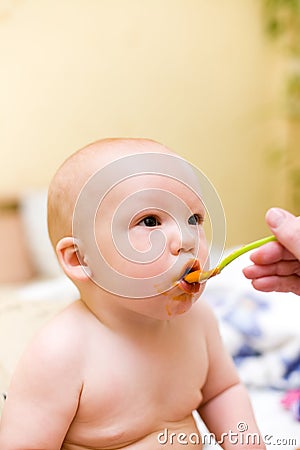 Mother feed baby by mashed melon Stock Photo