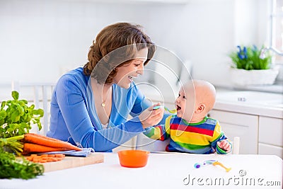 Mother feeding baby first solid food Stock Photo