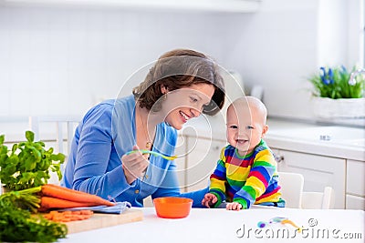 Mother feeding baby first solid food Stock Photo