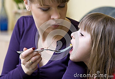 Mother feeding daughter Stock Photo