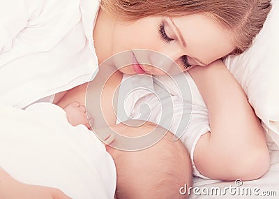 Mother feeding her baby in the bed. sleeping together Stock Photo