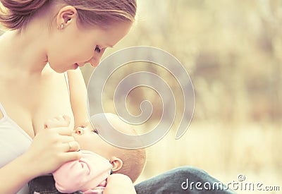 Mother feeding her baby in nature outdoors in the park Stock Photo