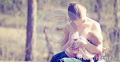 Mother feeding her baby in nature outdoors in the park Stock Photo