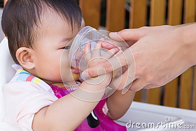 Mother feeding soup water for young kid eight month at home. Stock Photo