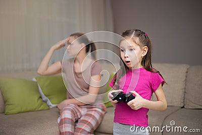 Mother frustrating that her doughter playing video games. Stock Photo