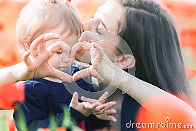 Mother with funny child outdoor at poppy flowers field Stock Photo