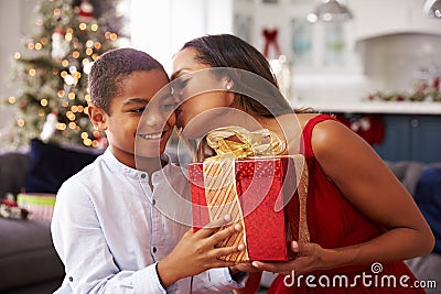 Mother Giving Christmas Presents To Son At Home Stock Photo