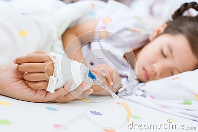 Mother hand holding sick daughter hand who have IV solution Stock Photo