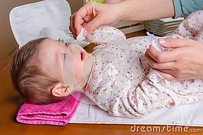 Mother hands cleaning eyes of baby with cotton Stock Photo