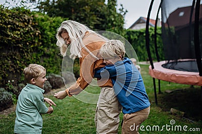 Mother having fun with sons in the garden, bonding moment. Concept of Mother& x27;s Day, and motherly love. Stock Photo