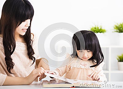 Mother helping child daughter to reading Stock Photo