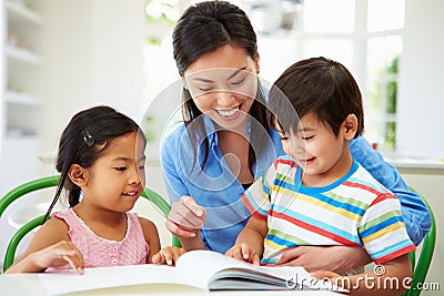 Mother Helping Children With Homework Stock Photo