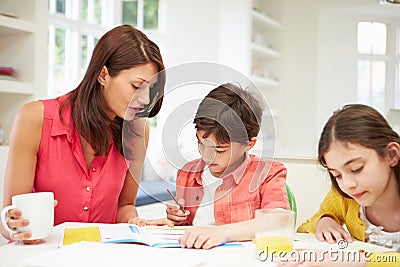 Mother Helping Children With Homework Stock Photo