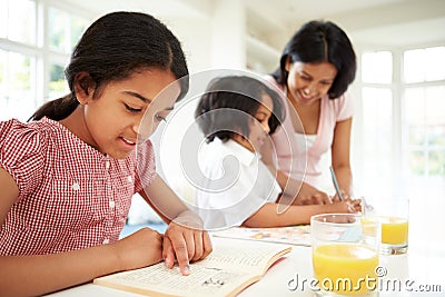 Mother Helping Children With Homework Stock Photo