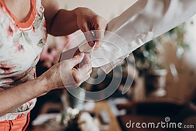 Mother helping groom putting on cuff links, getting ready in the Stock Photo