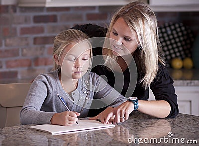 Mother helping her daughter with homework Stock Photo