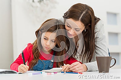 Mother Helping Her Daughter While Studying Stock Photo