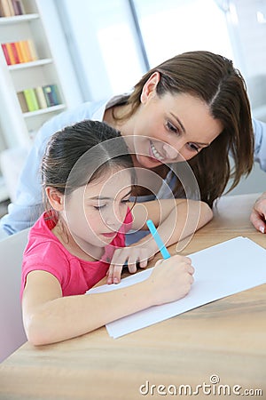 Mother helping her daughter to write Stock Photo