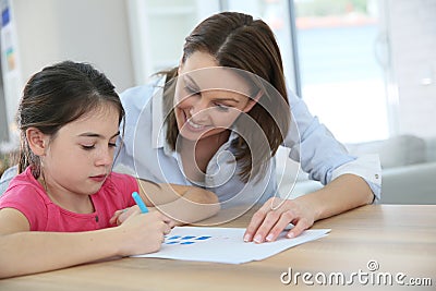 Mother helping her daughter writing Stock Photo