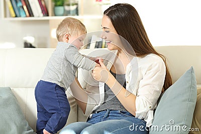 Mother helping to her baby to stand Stock Photo