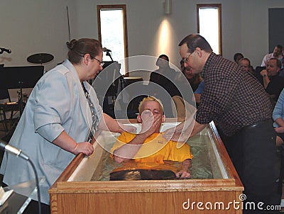 A mother helps to baptize her son Editorial Stock Photo