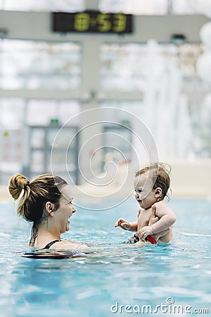 Mother with her baby daughter swim in the pool in waterpark Stock Photo