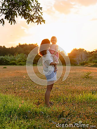 Mother with her baby girl with sunset tones in park Stock Photo